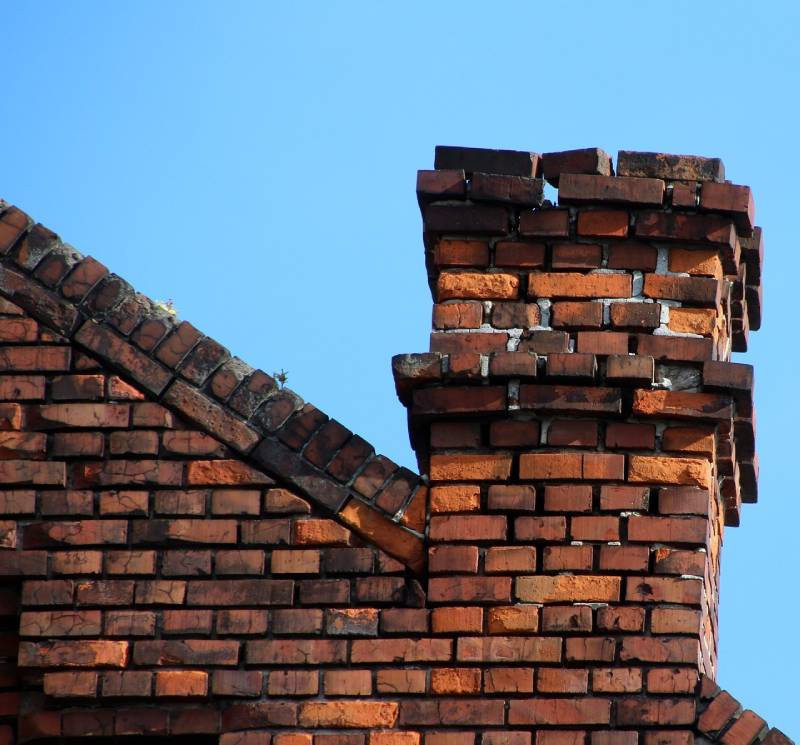 Signs Your Elmwood Park Home Needs a Chimney Inspection Blog Article - Damaged chimney on an Elmwood Park home showing cracks and missing mortar